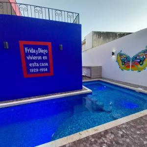 une piscine avec un panneau sur le côté d'un bâtiment dans l'établissement Condos Frida, à Cozumel