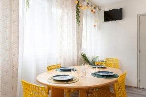 une salle à manger avec une table en bois et des chaises jaunes dans l'établissement Le Saint-Jean, à Metz
