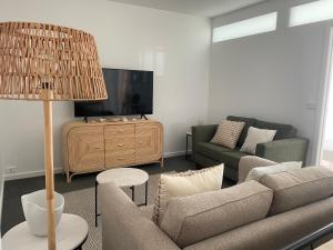 a living room with a couch and a tv at The Wheelhouse - 2BR Waterfront Apt in town in Lakes Entrance