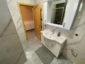 ein Badezimmer mit einem weißen Waschbecken und einem Spiegel in der Unterkunft Saray in Sarajevo