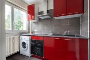 - une cuisine avec des placards rouges et un lave-linge dans l'établissement Le Saint-Jean, à Metz