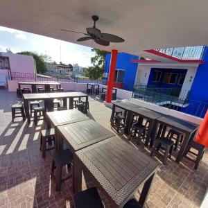 a group of wooden tables and chairs on a patio at Condos Frida in Cozumel