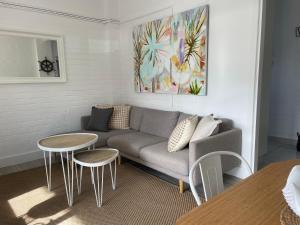 a living room with a couch and two tables at The Wheelhouse - 2BR Waterfront Apt in town in Lakes Entrance