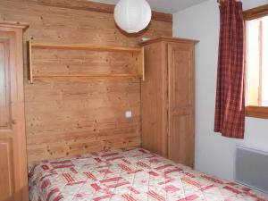 プラローニャン・ラ・ヴァノワーズにあるAppartement Pralognan-la-Vanoise, 3 pièces, 6 personnes - FR-1-464-24の木製の壁のベッドルーム1室(ベッド1台付)