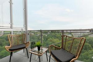 Duas cadeiras e uma mesa numa varanda em SKY Home- Wood Penthouse -Manufaktura, Parking, Klimatyzacja, Dostęp na Kod em Lódź