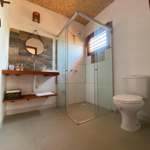 uma casa de banho com um WC e uma cabina de duche em vidro. em Pousada Villa Soleil icaraizinho em Icaraí