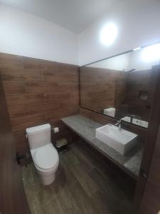 a bathroom with a toilet and a sink and a mirror at Terramar Hoteles in Crucita