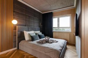 um quarto com uma cama e uma janela grande em SKY Home- Wood Penthouse -Manufaktura, Parking, Klimatyzacja, Dostęp na Kod em Lódź