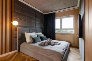 a bedroom with a bed with a large window at SKY Home- Wood Penthouse -Manufaktura, Parking, Klimatyzacja, Dostęp na Kod in Łódź