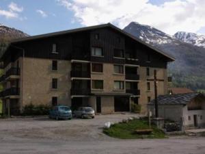 a large building with cars parked in a parking lot at Studio 3 pers. au pied des pistes avec balcon exposé sud, draps fournis, proche commerces - FR-1-508-76 in Lanslevillard