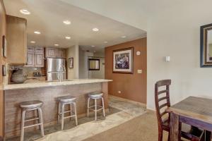 a kitchen with a bar with stools and a table at Ski In-Out Village at Breckenridge Condo in Breckenridge +31 photos