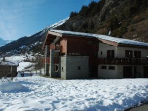 a building in the snow in front of a mountain at Appartement Lanslevillard, 2 pièces, 5 personnes - FR-1-508-131 in Lanslevillard