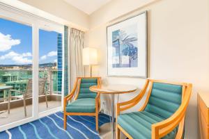 a hotel room with a table and chairs and a balcony at CASTLE at Ala Moana Hotel in Honolulu