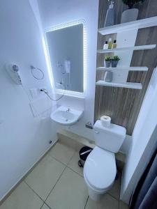 een witte badkamer met een toilet en een wastafel bij [H] Natural Holtin at Piura in Piura