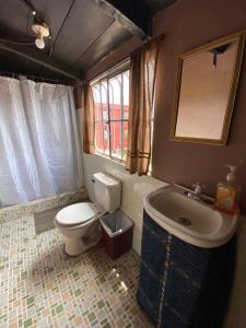 een badkamer met een toilet, een wastafel en een bad bij El Calvario Hostal in Cobán