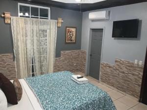 a bedroom with a bed and a tv on the wall at Apartamentos Casa Del Valle in San Pedro Sula