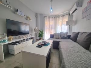 a living room with a couch and a tv at Apartamento Luna de Zahara - Situado en la zona tranquila del pueblo a 3 min de la playa y ocio in Zahara de los Atunes