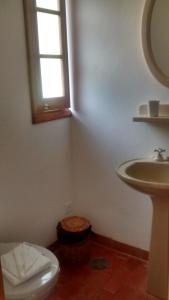 a bathroom with a sink and a toilet and a window at Refúgio do Selado in Monte Verde