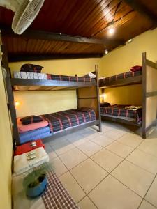 a room with three bunk beds in a room at El Calvario Hostal in Cobán