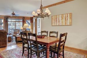 uma sala de jantar com uma mesa de madeira e cadeiras em Luxurious 2 Bedroom Condo 50 Feet From The Slopes! condo em Beaver Creek
