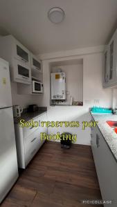 a kitchen with white appliances and a wooden floor at El Arroyo del Sur in San Carlos de Bariloche