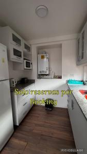 uma cozinha com electrodomésticos brancos e piso em madeira em El Arroyo del Sur em San Carlos de Bariloche