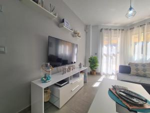a living room with a flat screen tv on a wall at Apartamento Luna de Zahara - Situado en la zona tranquila del pueblo a 3 min de la playa y ocio in Zahara de los Atunes