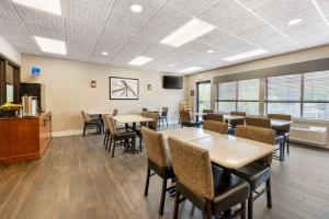 a dining room with tables and chairs and a tv at Best Western Spooner Riverplace in Shell Lake