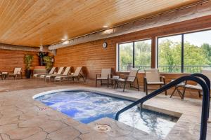 a swimming pool in a house with a wooden ceiling at Best Western Spooner Riverplace in Shell Lake