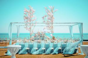 a wedding ceremony on the beach with chairs and a canopy at Ananti at Busan Cove in Busan
