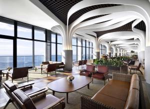 a lobby with chairs and tables and windows at Ananti at Busan Cove in Busan