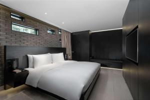 una camera da letto con un grande letto bianco e una televisione di The Temple House a Chengdu