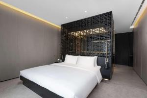 1 dormitorio con 1 cama blanca grande en una habitación en The Temple House en Chengdú