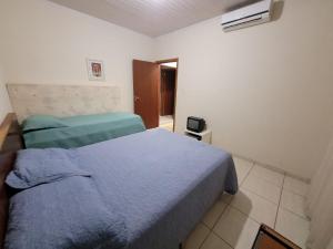 Casa para sua família في بونيتو: غرفة نوم مع سرير وبطانية زرقاء