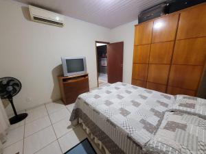a bedroom with a bed and a television in it at Casa para sua família in Bonito
