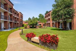 un patio de un edificio de apartamentos con flores rojas en Sonesta Select Boston Foxborough Mansfield, en Foxborough