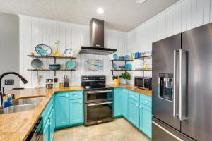 cocina con armarios azules y nevera de acero inoxidable en Charming Panama City Beach Retreat with Patio, en Panama City Beach