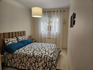 a bedroom with a bed with a black and white comforter at Ksota in Requena