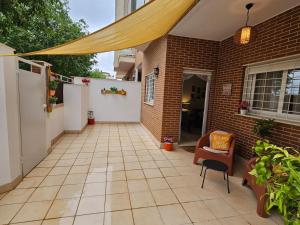 a patio with awning and a chair and a building at Ksota in Requena