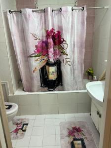 a bathroom with a vase of flowers in the bath tub at Appartement L'aouina cité wahat in Tunis