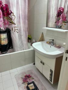 a bathroom with a sink and a bath tub with a mirror at Appartement L'aouina cité wahat in Tunis