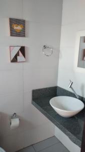 a bathroom with a bowl sink on a counter at Pousada Tio Pietro in Imbituba
