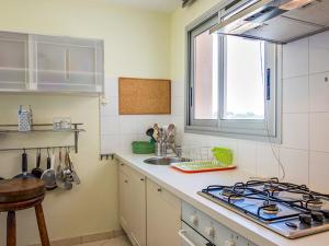 een keuken met een fornuis, een wastafel en een raam bij Appartement Mèze, 4 pièces, 6 personnes - FR-1-604-5 in Mèze