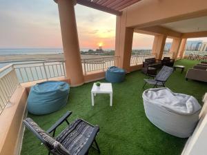 Un balcón con sillas, una mesa y el océano en رويال مارينا 2 بانوراما علي البحر مباشر عوائل فقط, en King Abdullah Economic City