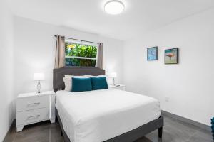 una camera da letto con un letto con cuscini blu e una finestra di Duplex Renovated Newly Furnished Spacious 2 Miles to Las Olas Riverfront Entertainment District 4 Miles to Beach a Fort Lauderdale