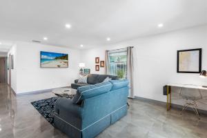 een woonkamer met een blauwe bank en een tafel bij Duplex Renovated Newly Furnished Spacious 2 Miles to Las Olas Riverfront Entertainment District 4 Miles to Beach in Fort Lauderdale