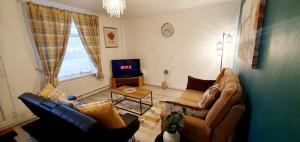a living room with a couch and a tv at Stourbridge House, Luxurious 3 Bedrooms - Ideal Location for Contractors and Families, Free Parking, Fast Wifi, Sleeps up to 8 in Lye