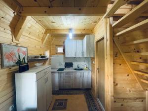 a kitchen in a log cabin with a refrigerator at Vikendica VIDIKOVAC na Piramidi Sunca in Visoko