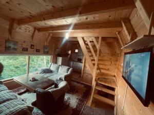 a living room with a couch and a large tv at Vikendica VIDIKOVAC na Piramidi Sunca in Visoko