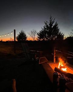 ein Feuer in einer Feuerstelle bei Sonnenuntergang in der Unterkunft Lazy Spring Farm 